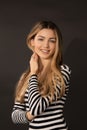 Portrait of beautiful happy blonde woman. Smiling broadly and looking at camera on black background in studio