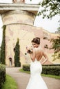 Portrait of a beautiful happy brunette bride in wedding white dress holding hands in bouquet of flowers outdoors Royalty Free Stock Photo