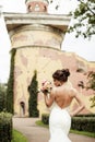 Portrait of a beautiful happy brunette bride in wedding white dress holding hands in bouquet of flowers outdoors Royalty Free Stock Photo