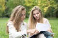 Portrait of a beautiful happy cheerful cute young ladies girls students sitting with copybooks in park Royalty Free Stock Photo