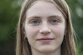 Portrait of a beautiful happy girl with blond hair and freckles looking at the camera and smiling charmingly, closeup, outdoors Royalty Free Stock Photo