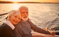 Portrait of a beautiful and happy senior couple in love hugging, relaxing and smiling while sailing together in the sea Royalty Free Stock Photo