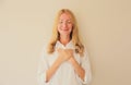 Portrait of beautiful happy smiling caucasian grateful woman put folded hands on her heart on white studio background Royalty Free Stock Photo