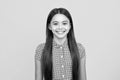 Portrait of beautiful happy smiling teenage girl on yellow studio background. Royalty Free Stock Photo