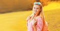 Portrait of beautiful happy smiling young blonde woman wearing backpack outdoors in autumn park Royalty Free Stock Photo