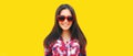 Portrait of beautiful happy smiling young brunette woman in red heart shaped sunglasses on yellow background Royalty Free Stock Photo