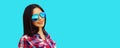 Portrait of beautiful happy smiling young brunette woman in sunglasses on blue background Royalty Free Stock Photo