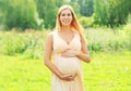 Portrait of beautiful happy smiling young pregnant woman walking in sunny summer day Royalty Free Stock Photo