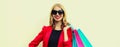 Portrait of beautiful happy smiling young woman with colorful shopping bags wearing a red business blazer on background Royalty Free Stock Photo