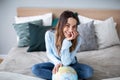 Portrait of a beautiful happy woman with a globe indoors