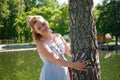 Portrait of beautiful happy woman in long blue dress near birch tree at summer sunny day. Attractive smiling woman in Royalty Free Stock Photo