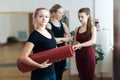 Portrait of beautiful happy yogi girl with pink hair holding folded red yoga mat after training lesson in fitness center or gym, h Royalty Free Stock Photo