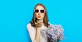 Portrait of beautiful happy young woman blowing kiss with bouquet of flowers Royalty Free Stock Photo