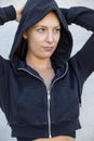 Portrait of beautiful, healthy, strong and fit young caucasian woman wearing a black hoodie flexing both arms muscles on Royalty Free Stock Photo