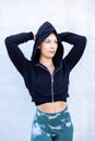 Portrait of beautiful, healthy, strong and fit young caucasian woman wearing a black hoodie flexing both arms muscles on Royalty Free Stock Photo