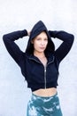 Portrait of beautiful, healthy, strong and fit young caucasian woman wearing a black hoodie flexing both arms muscles on Royalty Free Stock Photo