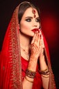 Portrait of beautiful indian girl in red bridal sari. Young hindu woman model with kundan jewelry set. Traditional Indian costume Royalty Free Stock Photo