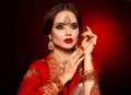 Portrait of beautiful indian girl in red bridal sari. Young hindu woman model with kundan jewelry set. Traditional Indian costume Royalty Free Stock Photo