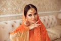 Portrait of beautiful indian girl in traditional saree in luxury interior. Young hindu woman model with kundan golden jewelry set