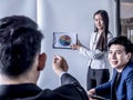 Portrait of beautiful intern standing at office in front of flip chart and presenting with team training flipchart office Royalty Free Stock Photo