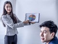 Portrait of beautiful intern standing at office in front of flip chart and presenting with team training flipchart office Royalty Free Stock Photo