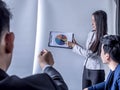 Portrait of beautiful intern standing at office in front of flip chart and presenting with team training flipchart office Royalty Free Stock Photo