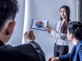 Portrait of beautiful intern standing at office in front of flip chart and presenting with team training flipchart office Royalty Free Stock Photo