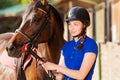 Beautiful jockey girl with her purebred bay horse Royalty Free Stock Photo