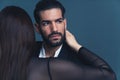 Portrait of a Beautiful Latin loving couple over dark background, studio shot
