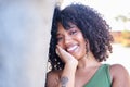 Portrait of beautiful latina woman. Smiling dreamy beautiful latina girl with black curly hair outside in the city