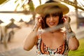 Portrait of beautiful latino woman smiling and looking at camera, wearing summer hat, posing during sunset Royalty Free Stock Photo