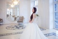Portrait of beautiful laughing bride. Wedding dress with open back. Luxurious light interior Royalty Free Stock Photo