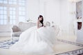 Portrait of beautiful laughing bride. Wedding dress with open back. Luxurious light interior Royalty Free Stock Photo