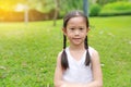 Portrait of beautiful little Asian child girl with two ponytail hair in the garden with morning sunlight Royalty Free Stock Photo