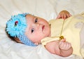 Portrait of a beautiful little baby girl in a yellow dress with a bow on her head that plays beads jewelry around his neck Royalty Free Stock Photo