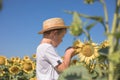 Portrait of beautiful little blond kid boy on summer sunflower field outdoors. Cute preschool child having fun on warm summer day Royalty Free Stock Photo