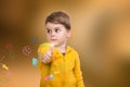 Portrait of beautiful little boy giving you thumbs up with flowers on background Royalty Free Stock Photo