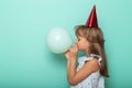 Little girl celebrating birthday and blowing a balloon Royalty Free Stock Photo