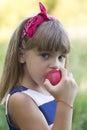 Portrait of a beautiful little girl while eating an apple outside Royalty Free Stock Photo