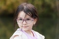 Portrait of a beautiful little girl with glasses in the park Royalty Free Stock Photo