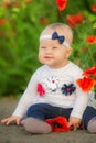 Portrait of a beautiful little girl having fun in field of red poppy flowers in spring. Royalty Free Stock Photo