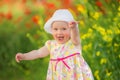 Portrait of a beautiful little girl having fun in field of red poppy flowers in spring. Royalty Free Stock Photo