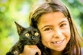 Portrait of a beautiful little girl holding a black cat Royalty Free Stock Photo