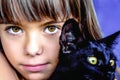 Portrait of a beautiful little girl holding a black cat Royalty Free Stock Photo