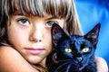 Portrait of a beautiful little girl holding a black cat Royalty Free Stock Photo