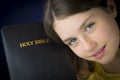 Portrait of beautiful little girl holding Holy Bible