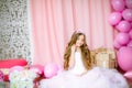 A portrait of a beautiful little girl in a studio decorated many color balloons