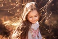 Portrait of a beautiful little girl with long hair in the woods on nature