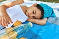 Portrait of a beautiful little girl lying on the blanket with lemons in the park. Kid having cozy summer picnic with the family. Royalty Free Stock Photo