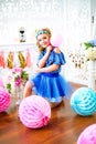 A portrait of a beautiful little girl in a studio decorated many color balloons